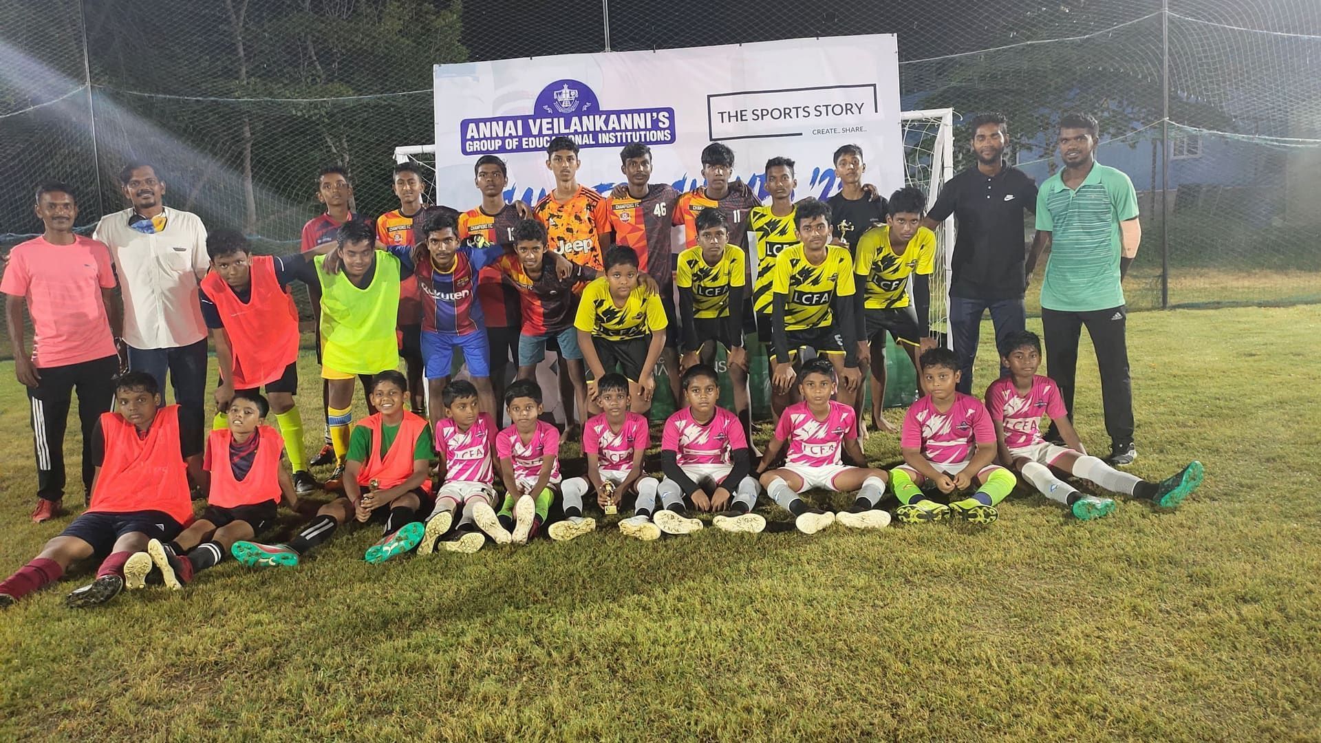 Floodlit football tournament team photo with trophies