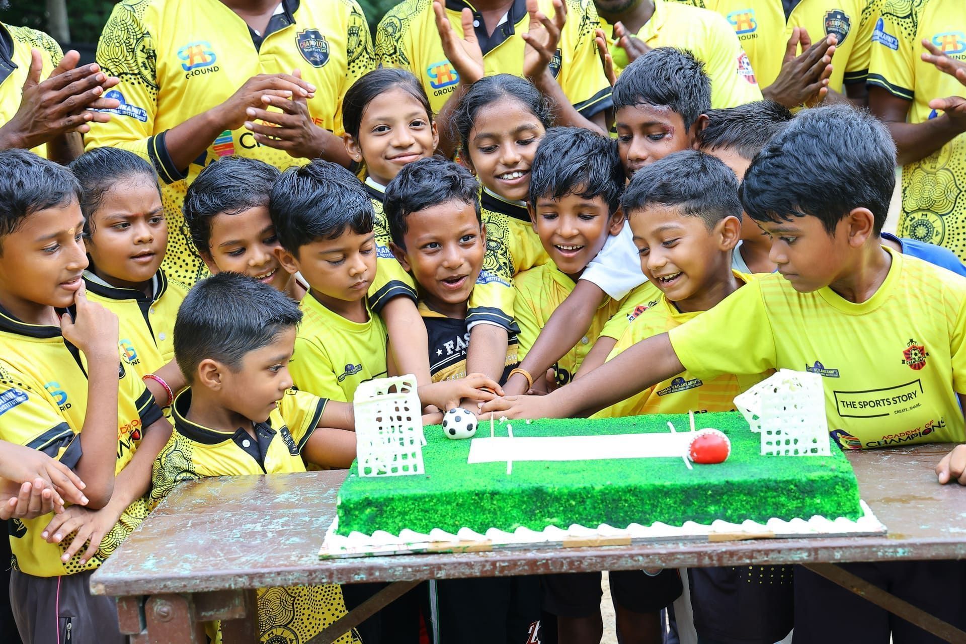 Academy juniors celebrating an anniversary with a sports-themed cake